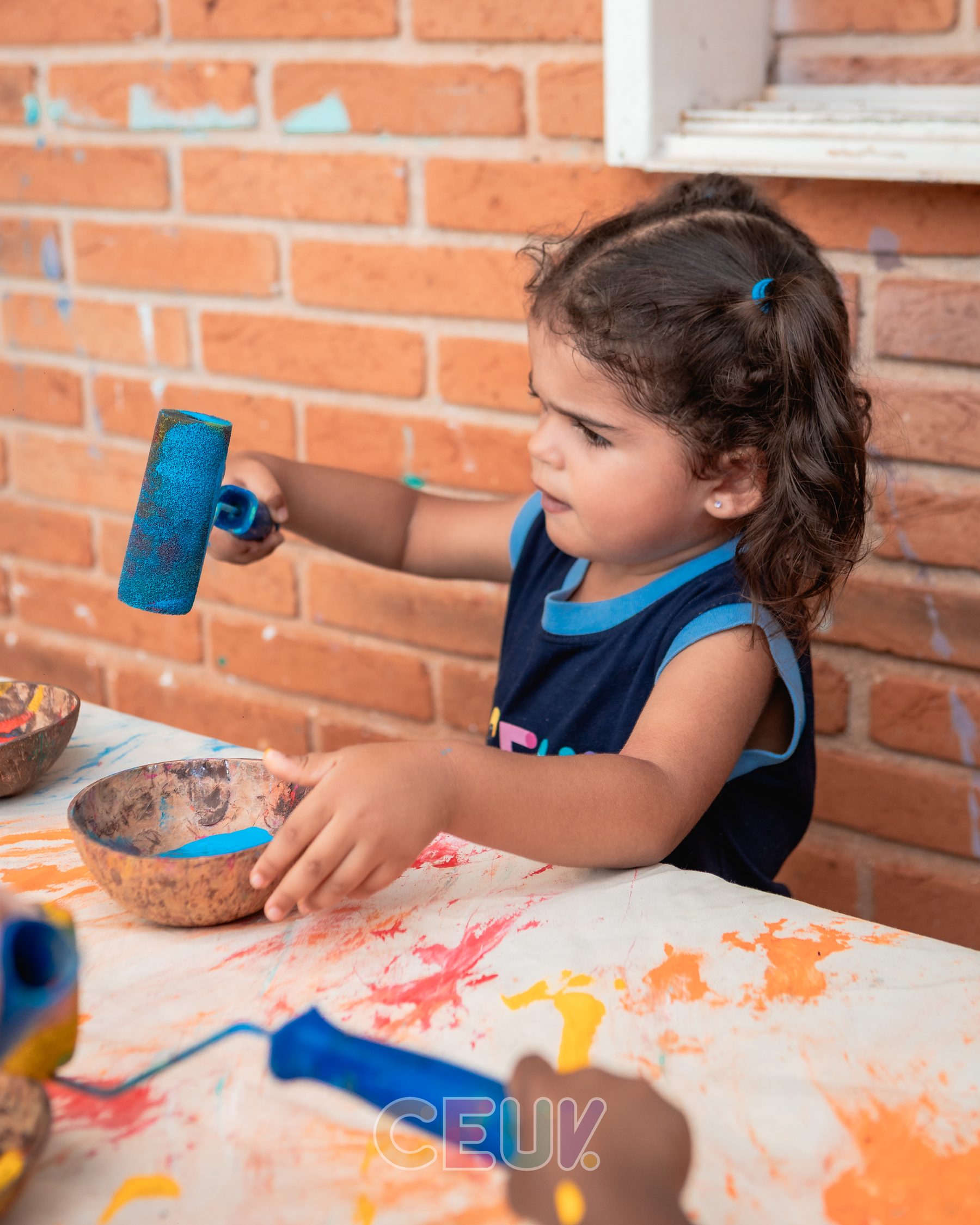 Crianças do CEUV pintando parede juntas