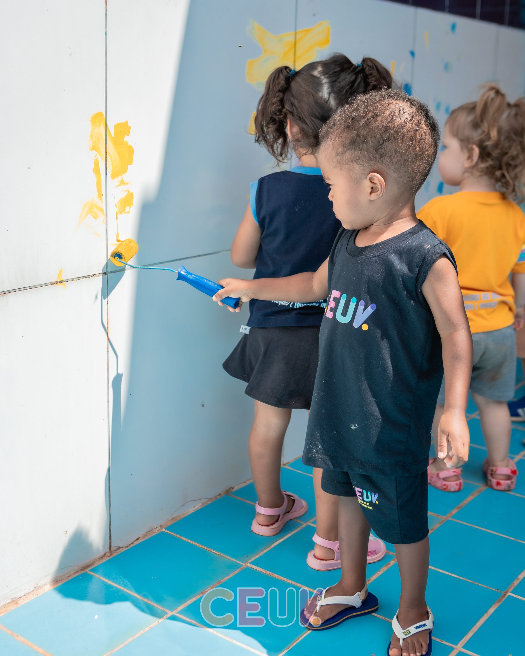 Crianças do CEUV brincando na parede azulejada