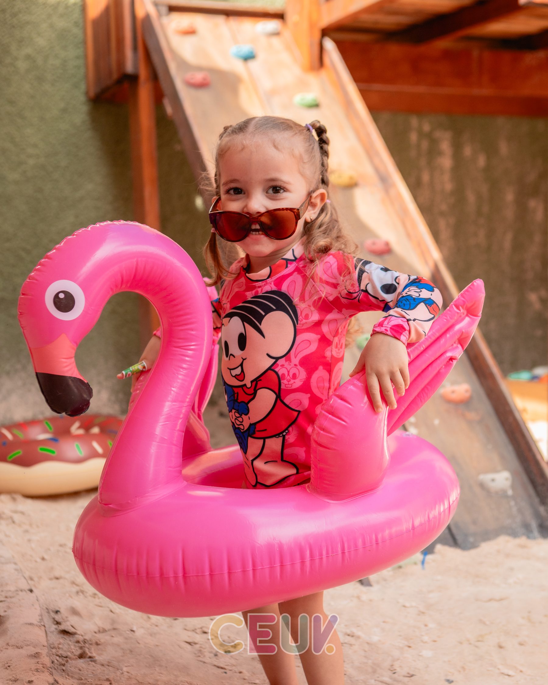 Aluna do CEUV brincando com boia em formato de flamingo